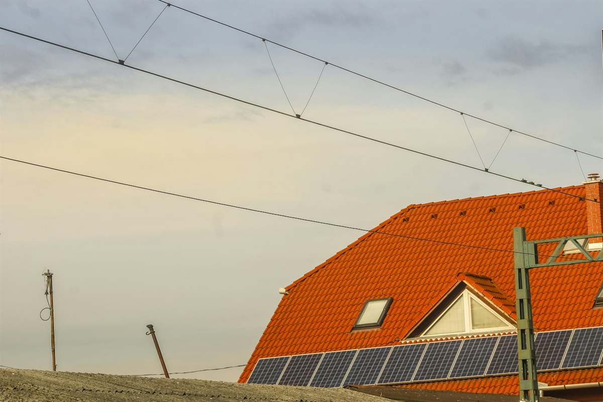 Telhado de telha cerâmica alaranjada com módulos fotovoltaicos instalados